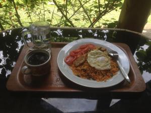 un plato de comida en una bandeja con un vaso de cerveza en Orau Inn en Sarilamak