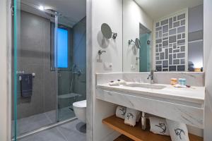 a bathroom with a sink and a shower and a toilet at Glyfada Riviera Hotel in Athens