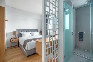 a bedroom with a bed and a glass door at Glyfada Riviera Hotel in Athens