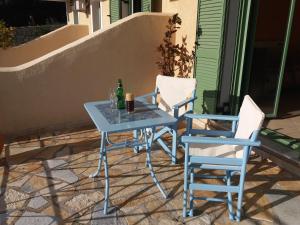 a blue table and two chairs and a bottle of beer at Vegera Apartment M in Vasilikiádhes