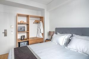 a bedroom with a bed with white sheets and white pillows at Glyfada Riviera Hotel in Athens