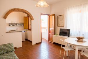 a kitchen and a living room with a table and a kitchen and a dining room at Casa_Molara in Porto San Paolo