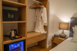 a hotel room with a bedroom with a bed and a tv at Glyfada Riviera Hotel in Athens