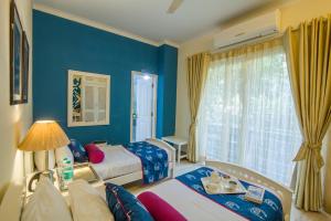 a hotel room with two beds and a window at Colonel’s Retreat in New Delhi