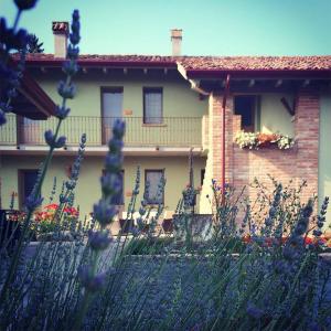 una casa con flores púrpuras delante de ella en Agriturismo Bassanine, en Monticelli dʼOngina