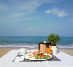 a plate of food on a beach near a body of water at Lanta Nice Beach Resort - SHA Extra Plus in Ko Lanta