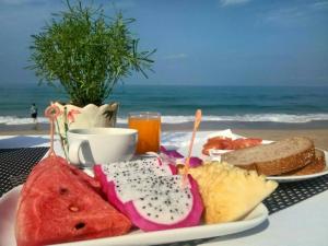 a table topped with a plate of food and a drink at Lanta Nice Beach Resort - SHA Extra Plus in Ko Lanta