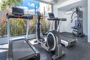 a gym with two tread machines and a treadmill at Glyfada Riviera Hotel in Athens