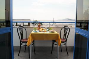 a table with a yellow table cloth and two chairs at Hotel Villa Del Mare in Bacoli