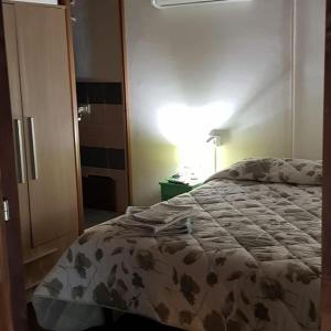 1 dormitorio con 1 cama, vestidor y lámpara en Affittacamere Luti, en Massama