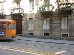 Il Sogno Torino Guesthouse في تورينو: حافلة برتقال متوقفة أمام مبنى