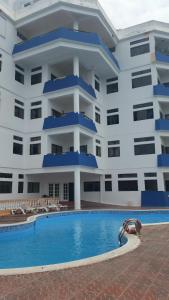 サントドミンゴにあるApartamento Residencial Costa Azulの大きな建物で、目の前にスイミングプールがあります。
