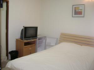 1 dormitorio con cama y vestidor con TV en TK Guesthouse, en Cha Am
