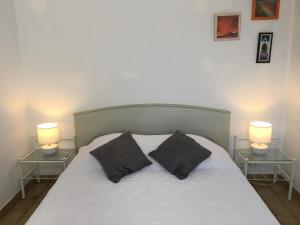 uma cama com duas mesas de cabeceira e dois candeeiros em Gîte à Poggiale de Figari em Figari