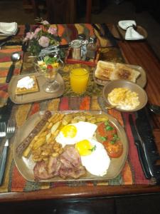a table with a breakfast of eggs and meat and bread at Khokha Moya Guesthouse in Ermelo