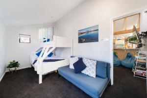 een slaapkamer met een stapelbed en een blauwe bank bij Central, Modern Loft Style Home - 2 Min walk from Town in Queenstown