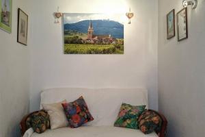 un divano bianco in una stanza con una foto sul muro di Gites-Weyer La maison a Bergheim