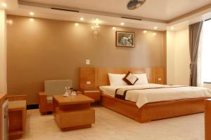 a bedroom with a bed and a desk and a chair at Thanh Bình Gold Hotel in Sầm Sơn +49 photos