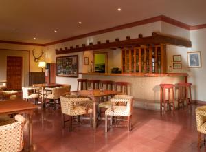 un restaurante con mesas y sillas y un bar en Parador de Cazorla, en Cazorla