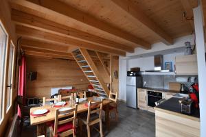 a kitchen with a wooden table and a ladder at chalet perché in LʼHuez