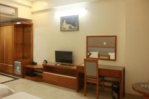 a room with a desk with a television and a mirror at Thanh Bình Gold Hotel in Sầm Sơn