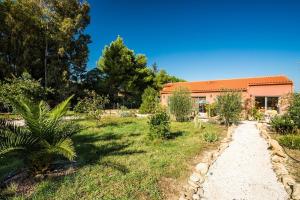 a garden with a house in the background at Chambres d'hôtes l'Olivette des Albères in Saint-André