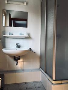 a bathroom with a sink and a shower at Hotel Mivano Lehrte in Lehrte