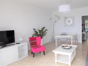 a living room with a pink chair and a table at Escape to the French Riviera in Villefranche-sur-Mer