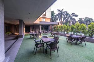 a restaurant with tables and chairs on a patio at Princeton Club in Kolkata