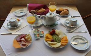 a table with plates of food and glasses of orange juice at Quinta dos Poetas Nature Hotel & Apartments in Olhão