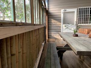a porch with a wooden table and a window at 嘉樂的家民宿Tea Master B&B 電動車充電站 in Lugu Lake