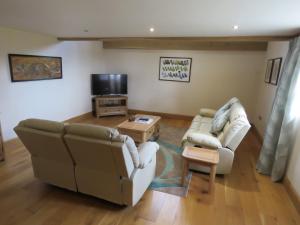 a living room with two couches and a tv at Welsh Apple Barn in Chepstow