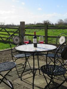 een tafel met twee glazen wijn erop bij Welsh Apple Barn in Chepstow