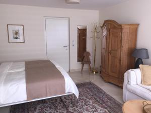 ein Schlafzimmer mit einem Bett, einem Sofa und einem Stuhl in der Unterkunft Chalet am See in Nassereith