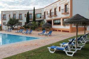 un hôtel avec des chaises longues et une piscine dans l'établissement Quinta dos Poetas Nature Hotel & Apartments, à Olhão