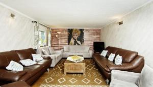 ein Wohnzimmer mit Ledersofas und einem Couchtisch in der Unterkunft Ferienhaus im Grünen Eifel in Schleiden