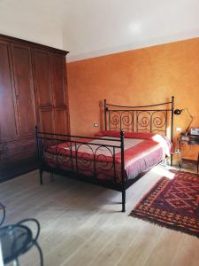a bedroom with a bed with a red bedspread at Casa Mosaico in Volterra