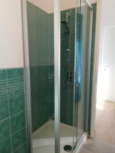 una doccia con porta in vetro in bagno di Casa Mosaico a Volterra