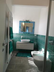 a bathroom with a sink and a toilet and a mirror at Casa Mosaico in Volterra