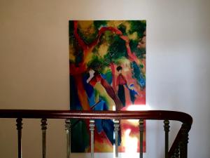 a painting hanging on a wall next to a staircase at La Domitia - Maison d'hôtes, spa & massages in Montbazin