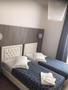 a bedroom with two beds with white pillows at Hotel Centrale in Trieste