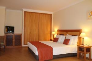 a hotel room with a bed and a television at Quinta dos Poetas Nature Hotel & Apartments in Olhão