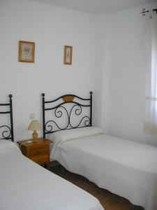 1 dormitorio con 2 camas y mesa con lámpara en Alquiler Vacaional Verano en Zahara de Los Atunes, en Zahara de los Atunes