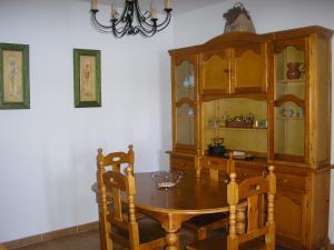 a dining room with a wooden table and a cabinet at Alquiler Vacaional Verano en Zahara de Los Atunes in Zahara de los Atunes
