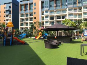 a playground with slides and an umbrella in front of a building at Laguna Beach Resort 2 in Jomtien Beach