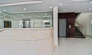 a lobby with a reception counter and a staircase at Treebo Trend Blu Orchid in Bangalore