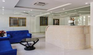 a lobby with a blue couch and a table at Treebo Trend Blu Orchid in Bangalore