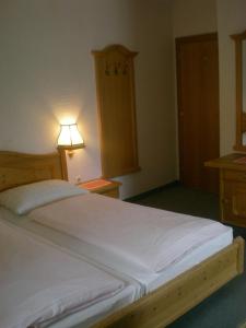 a bedroom with a large white bed and a lamp at Frühstückspension Laßhofer in Mauterndorf