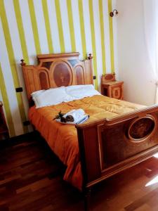 een slaapkamer met een bed met een houten hoofdeinde bij La Casa del susino in Castiglione dʼOrcia