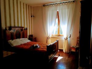 a bedroom with a bed and a window at La Casa del susino in Castiglione dʼOrcia